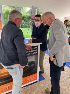 trois personnes devant la table de EUROCOC sur la conferance